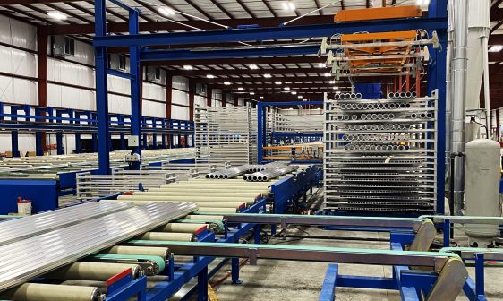 Numerous long aluminum extrusion pieces moving through the production line.