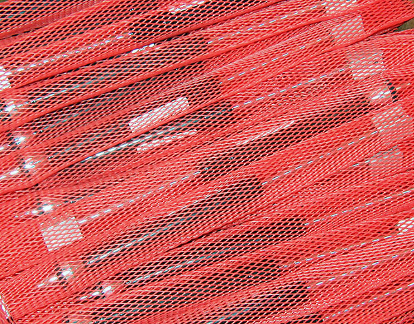 Red netting encasements for individual parts for shipping.