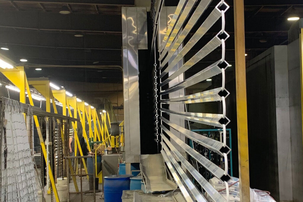 Aluminum Finishing Services showing hung extrusions going through the powder coating line.